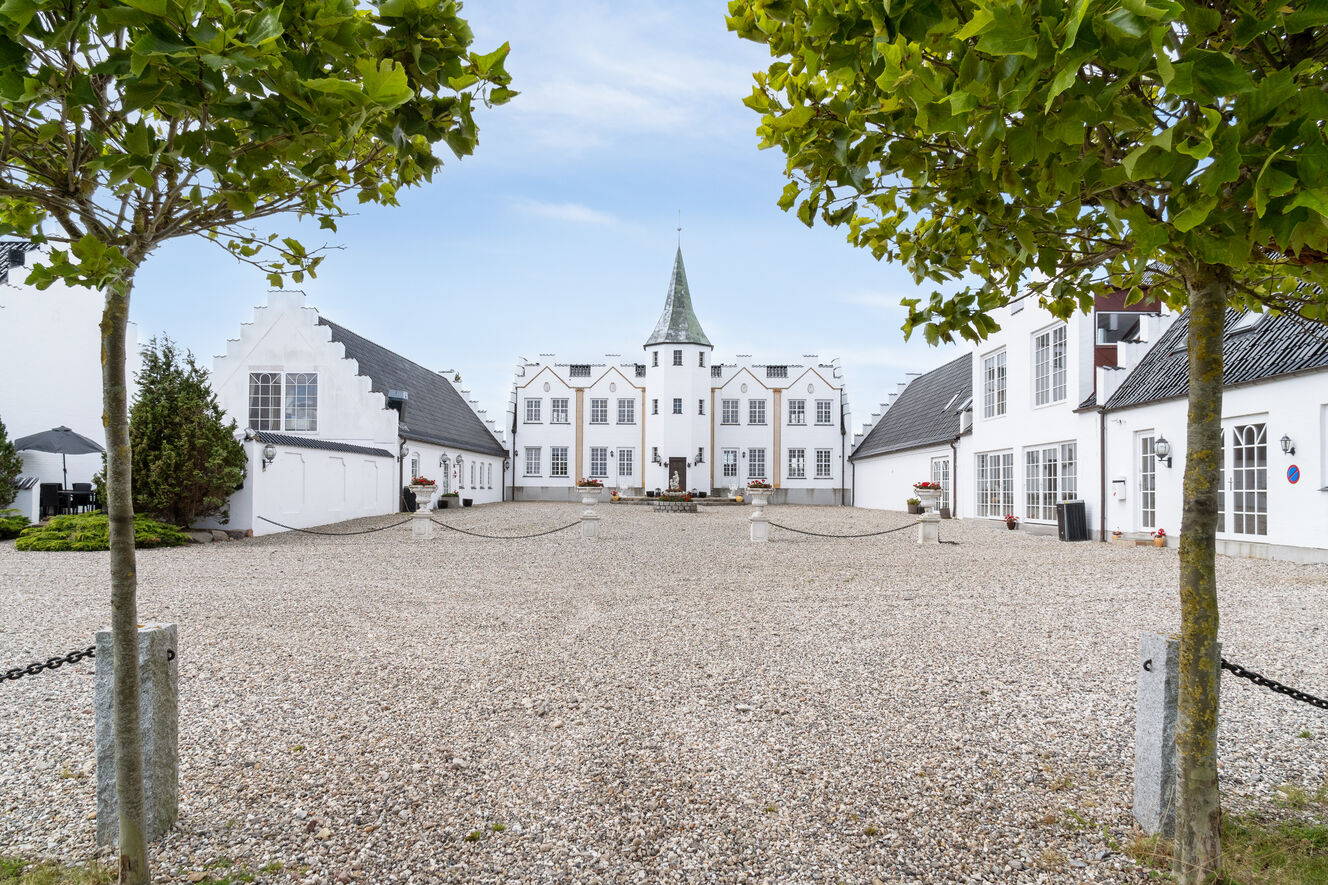 Smuk slotsgård med hvide bygninger – bryllup på Fyn